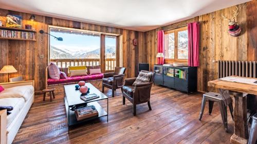 - un salon avec des boiseries et une vue sur la montagne dans l'établissement Montjoie, aux Contamines-Montjoie