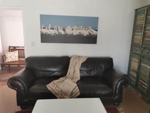 a black leather couch sitting in a living room at The Rez Guesthouse in Walvis Bay