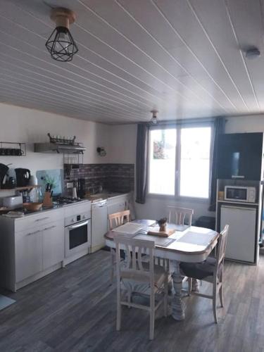 a kitchen with a table and a table and chairs at Gîte la tourterelle in Rancy