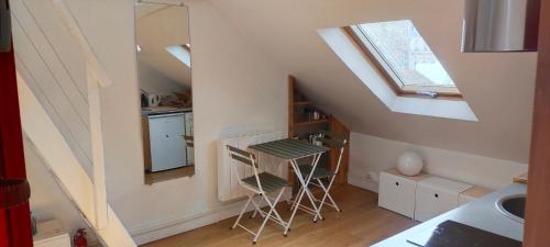 - une cuisine mansardée avec deux tabourets et un évier dans l'établissement Studio sous les toits et mezzanine - Vincennes, à Vincennes