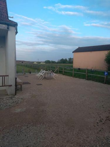 a park with a bench and a fence and a building at Gîte la tourterelle in Rancy