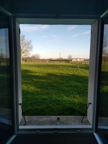 a window with a view of a field of grass at Gîte la tourterelle in Rancy