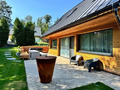 a patio with chairs and a large trash can next to a house at bystřice park Chata Voda in Včelákov