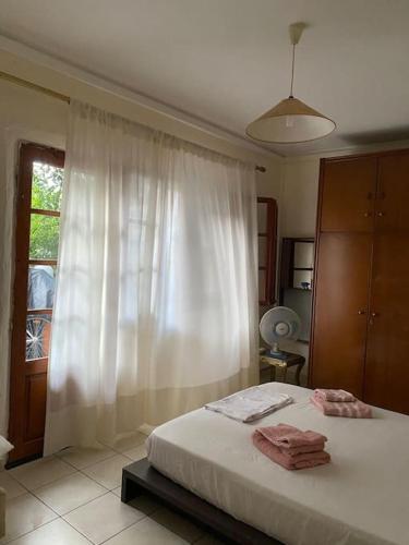 a bedroom with a bed with white curtains and a window at Sandras apartment in Igoumenitsa