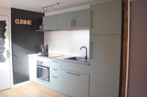 une cuisine avec des armoires blanches et un évier dans l'établissement La Tour du Rempart - Appartement T2 en duplex en hypercentre de Colmar, à Colmar