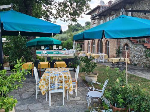 a patio with a table and chairs and umbrellas at Maison Brinati Bed and Breakfast in Monsummano
