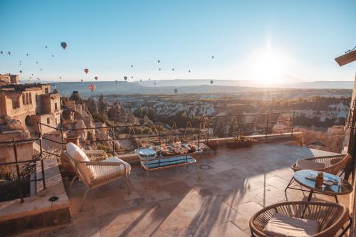 a balcony with chairs and a view of the city at Very Peri Cappadocia - The Lifestyle Luxury Design Hotel in Uchisar