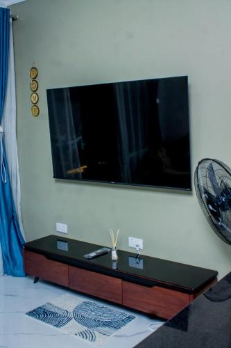 a living room with a tv on the wall at Onelove Homes in Lusaka