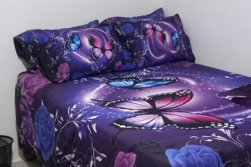 a purple bed with butterflies on it at Lovely 2 Bedroom House in St Thomas Jamaica in Belfast