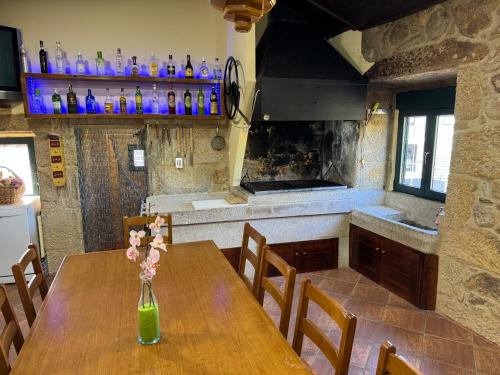 Una cocina con una mesa de madera con un jarrón de flores encima. en Casa Costeira, en Redondela
