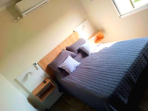 Schlafzimmer mit einem Bett mit lila Bettwäsche und Kissen in der Unterkunft PH SomoS in San José