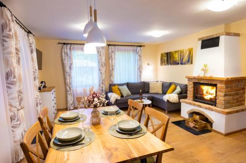 a living room with a table and a fireplace at e-Pagony Dunakanyar- Privát erdei szállás in Kismaros