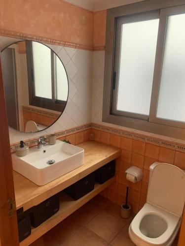 a bathroom with a sink and a mirror and a toilet at Excelsior Beachfront Apartment Calpe in Calpe
