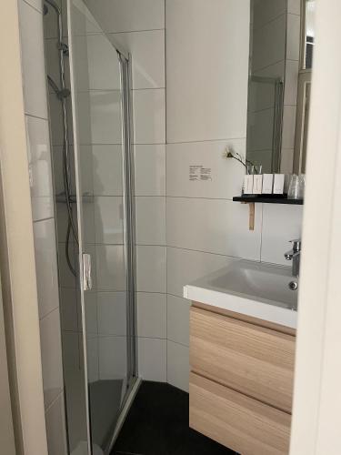 a bathroom with a shower and a sink at Hotel Au Quartier in Maastricht