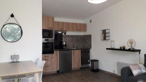 une cuisine avec une table et une salle à manger dans l'établissement Gîte Ty Laouen Clohars-Carnoët, à Clohars-Carnoët