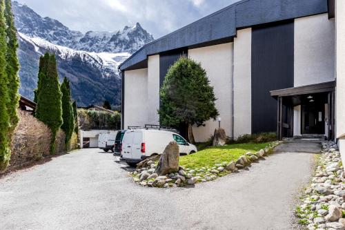 une voiture garée à l'extérieur d'un bâtiment avec des montagnes en arrière-plan dans l'établissement Sun Valley 1 - calme - Acces bus - Proche lac, à Chamonix-Mont-Blanc