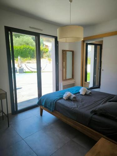 - une chambre avec un grand lit et des portes coulissantes en verre dans l'établissement La maison de la colline, à Gardanne