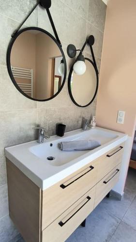 une salle de bain avec un lavabo et un miroir dans l'établissement La maison de la colline, à Gardanne