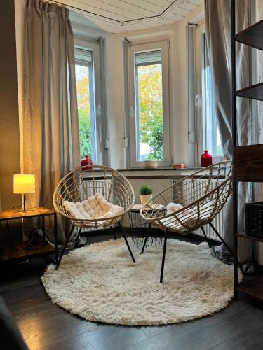 a living room with two chairs and a table at Cozy Oldhouse Appartment Varenseller in Rheda-Wiedenbrück