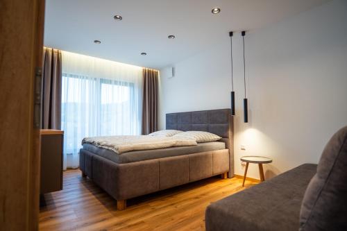 a bedroom with a bed and a couch at Villa Studenec in Banská Štiavnica
