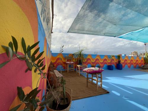 a room with a colorful wall with a table and chairs at Buena vista morroco GUEST HOUSE in Tamraght Ouzdar