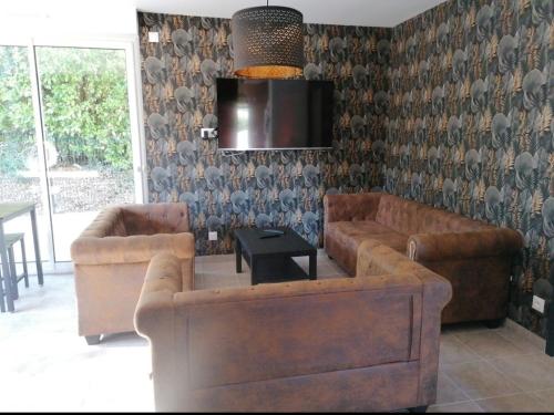 un salon avec deux canapés et une télévision dans l'établissement La villa de Sofie, à Lantic