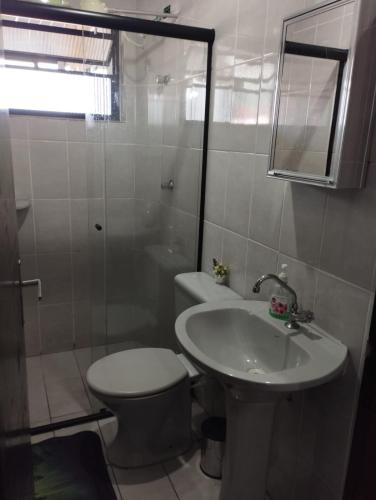 a bathroom with a toilet and a sink and a shower at Nossa kit in Praia Grande