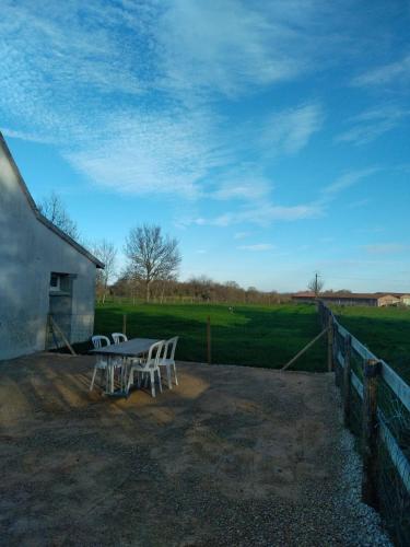 a table and chairs sitting next to a barn at Gîte la tourterelle in Rancy