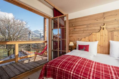 a bedroom with a bed and a large window at Kitzhof Mountain Design Resort in Kitzbühel