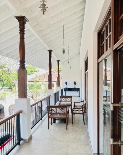 a porch with two chairs and a table on it at La Maison de Colombo in Colombo