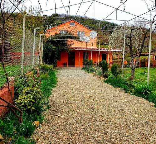 un edificio naranja con una valla delante en your home for a day, en Mamkoda