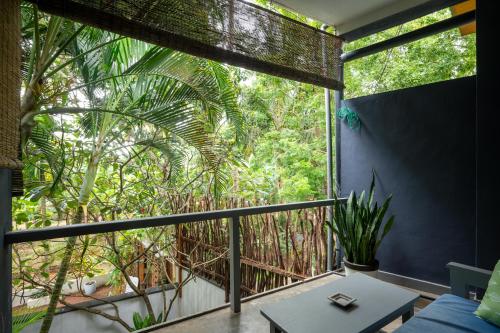 a room with a balcony with a large window at Salt House in Hiriketiya