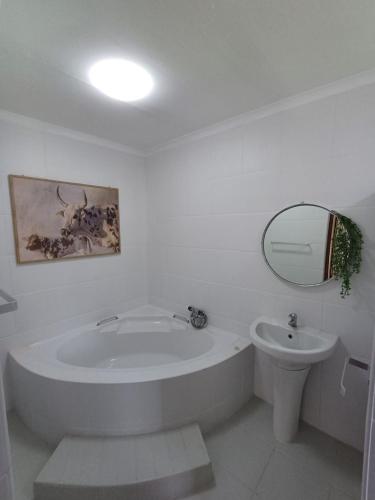 a white bathroom with a tub and a sink at Grootfontein Farm accommodation in Stilbaai