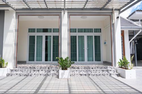 a front porch of a house with glass doors at Garden House Rice Field and Mountain View in Luang Prabang