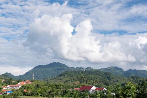 a view of a mountain range with houses and trees at Garden House Rice Field and Mountain View in Luang Prabang