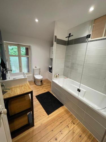 une salle de bain avec une baignoire, un lavabo et des toilettes dans l'établissement Marcart, sur le sentier du Miosson Saint Benoit, à Saint-Benoît