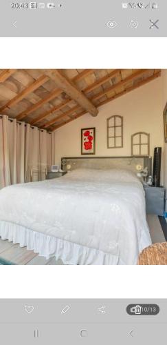 - une chambre avec un grand lit blanc dans l'établissement Le grenier de Marie, à Saint-Laurent-dʼAigouze