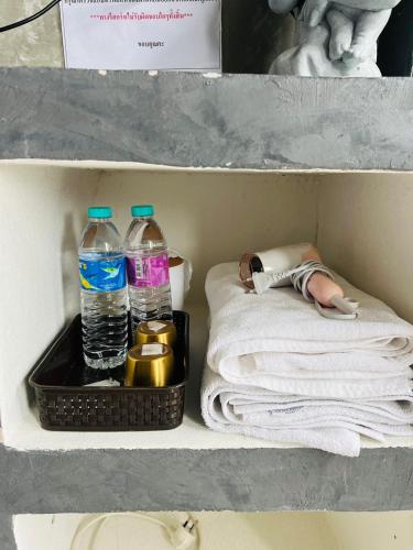 a shelf with two bottles of water and towels at ริมยมรีสอร์ท in Ban Wang Din