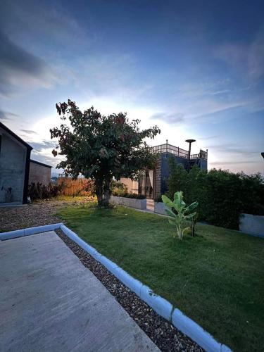 a house with a yard with a tree in the yard at ริมยมรีสอร์ท in Ban Wang Din