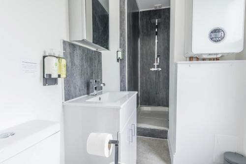 a white bathroom with a sink and a shower at Luxury Skyfall with FREE PARKING For Families & Business By Prescott Apartments in Bristol