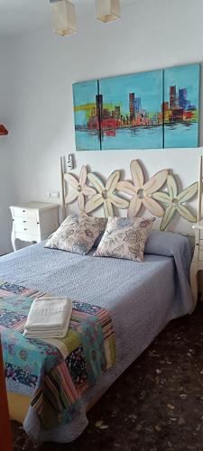 a bedroom with a bed with flowers on the wall at Alojamiento Entradita Cazorla in Cazorla