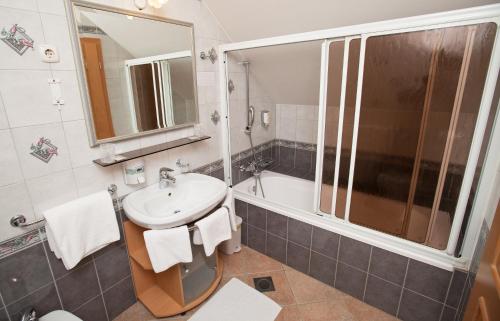 a bathroom with a sink and a shower at Guesthouse Tulipan in Lesce