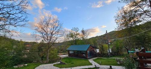 a small building with a blue roof in a garden at Cabana Pietrar in Feneş