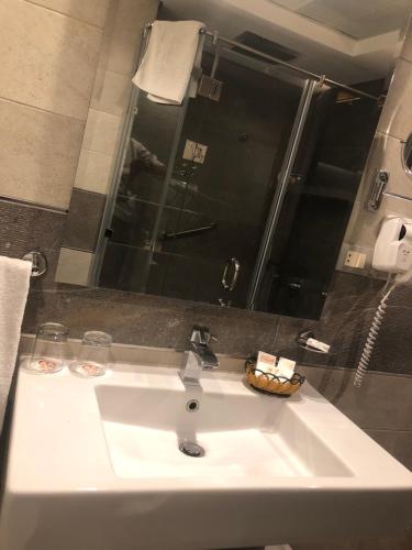 a white sink in a bathroom with a shower at Maadi Hotel in Cairo
