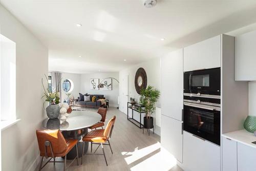 a kitchen and living room with a table and chairs at 3 Rockham - Luxury Apartment at Byron Woolacombe in Woolacombe