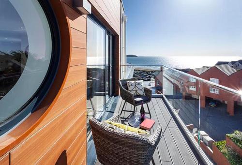 a balcony with a chair on top of a building at 3 Rockham - Luxury Apartment at Byron Woolacombe in Woolacombe