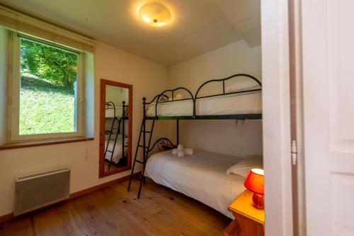 een slaapkamer met twee stapelbedden en een raam bij La Grande Savoyarde in Chamonix-Mont-Blanc