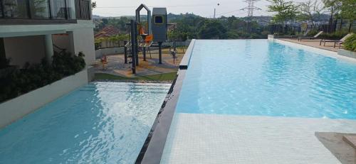 a large swimming pool with a playground in a building at HABITUS Elmina Denai Alam in Shah Alam
