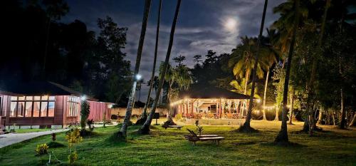 a building with lights in a park at night at Raflow Resort Raja Ampat in Tapokreng