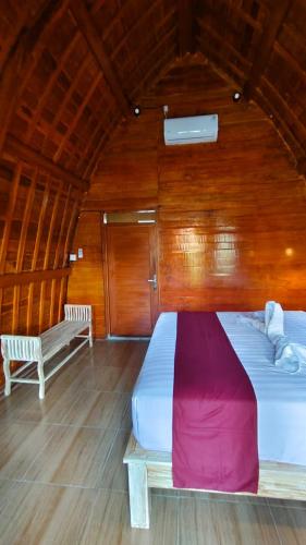 a large bed in a room with wooden walls at Green Pacing Lodge in Bangli